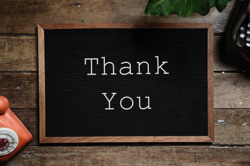 Small chalkboard on a desk with Thank You written on it