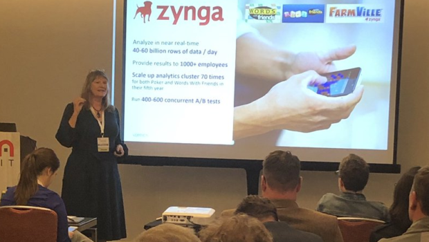 Paige Roberts presenting to a full room with a Zynga case study slide showing