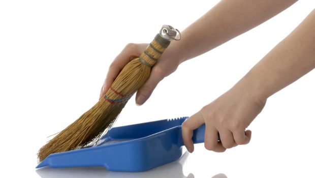 hands sweeping into a dustpan