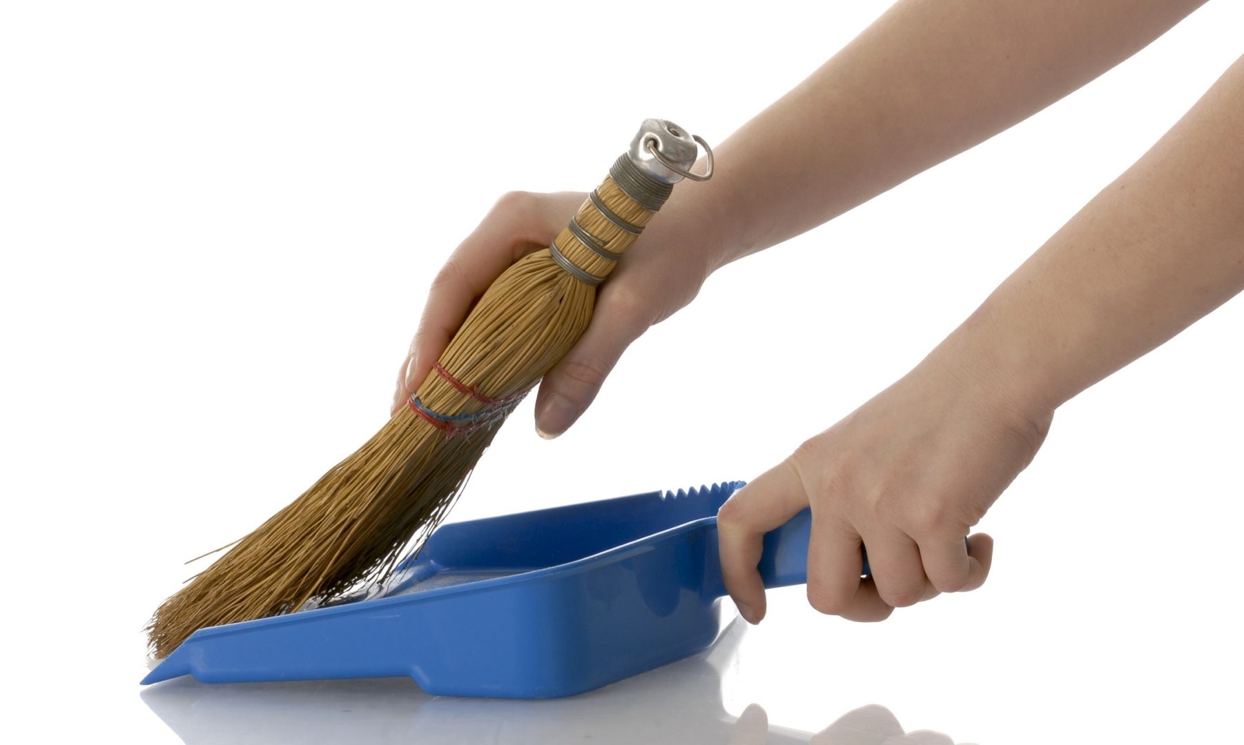 hands sweeping into a dustpan