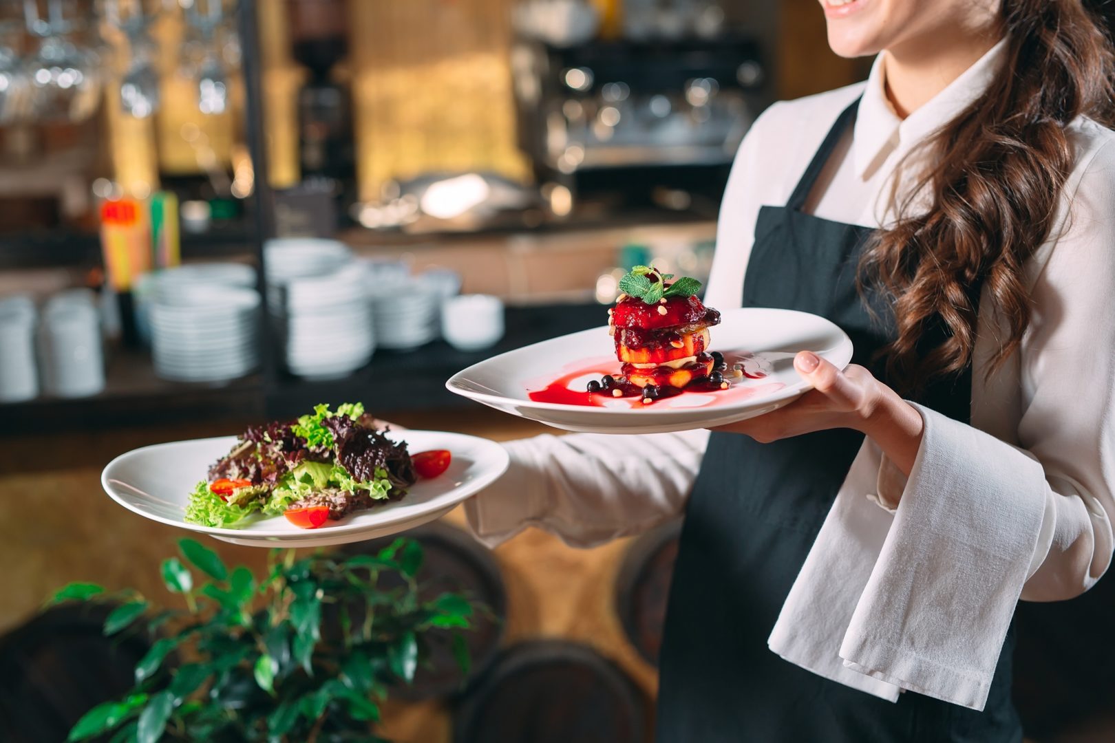 Restaurant server in uniform with beautiful food dishes